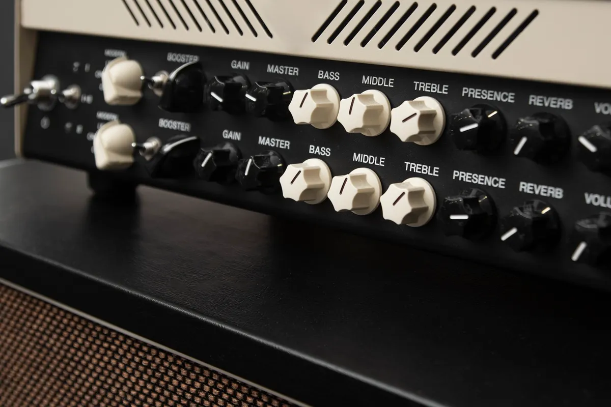 Painel de um amplificador de som com botões de ganho, master, graves, médios, agudos, presença e reverb.