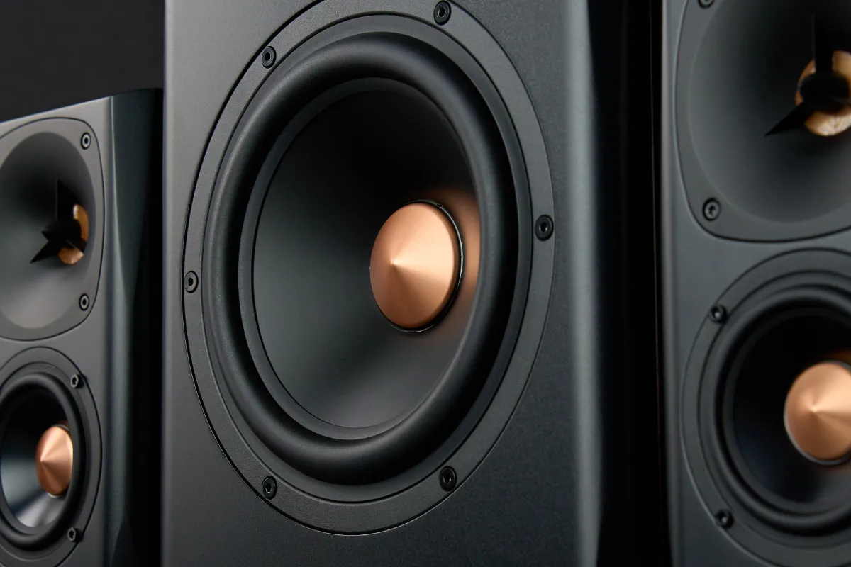 Close em um subwoofer de caixa de som com dois alto-falantes ao fundo em um sistema de áudio.
