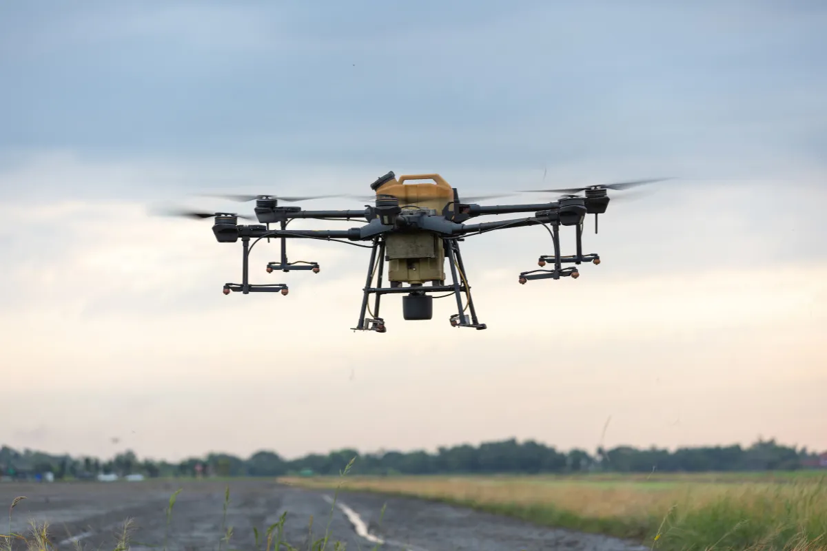 drone profissional de grande porte voando sobre estrada em área aberta