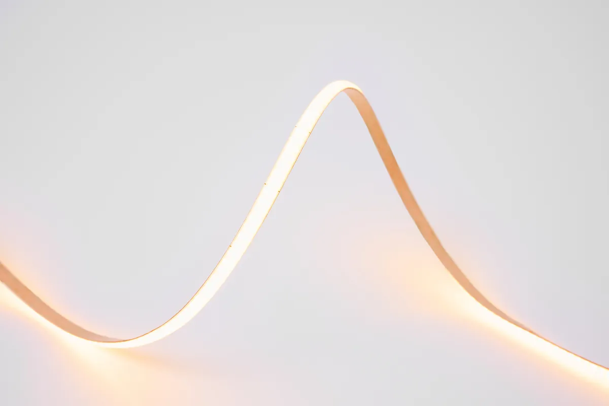 Fita de LED branco quente formando uma curva suave sobre fundo claro