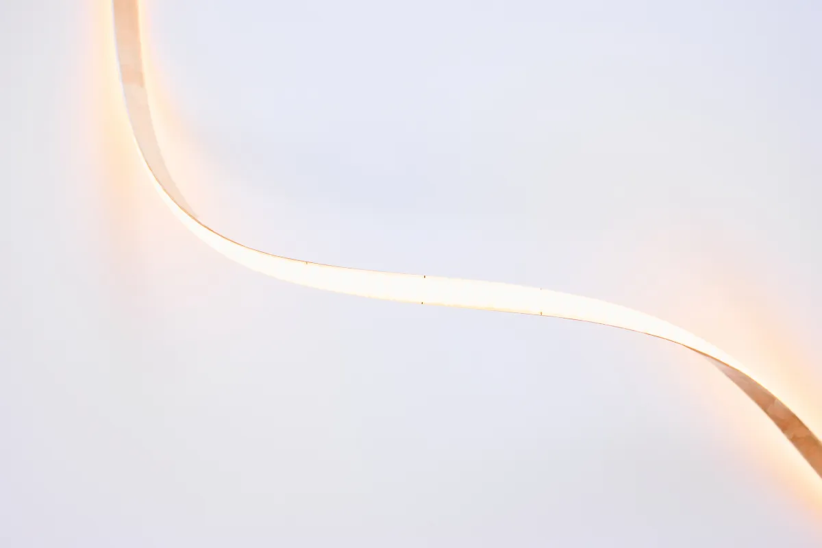 Fita de LED branco quente formando uma linha contínua sobre fundo claro