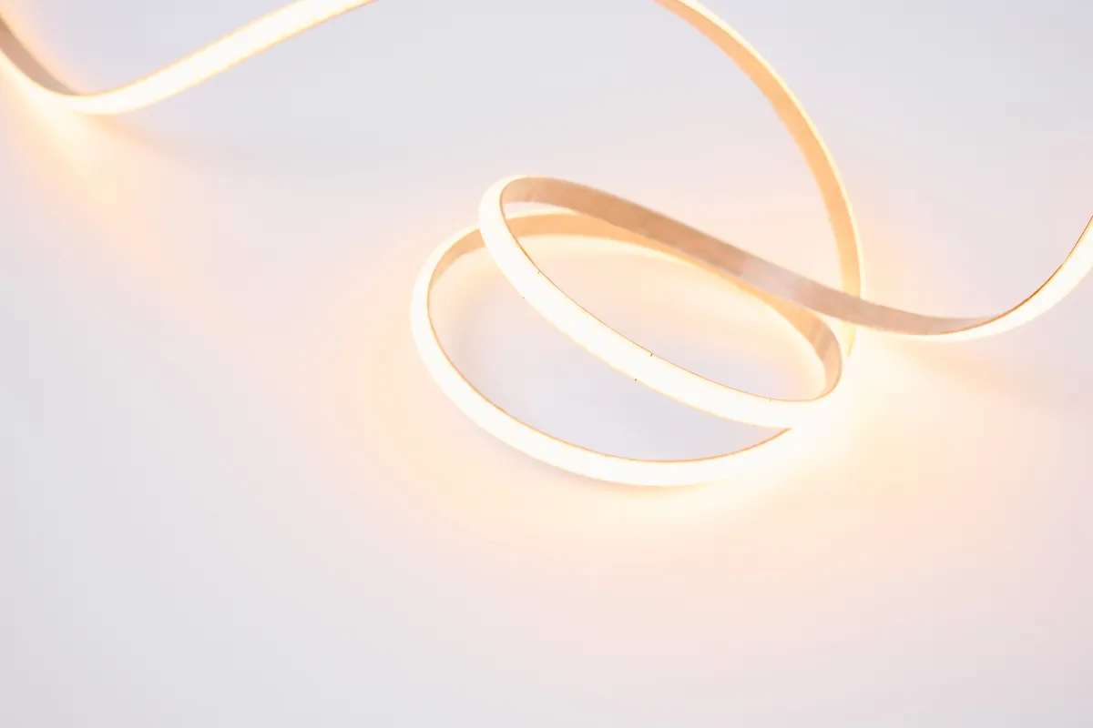 Fita de LED branco quente enrolada em formato circular sobre superfície clara