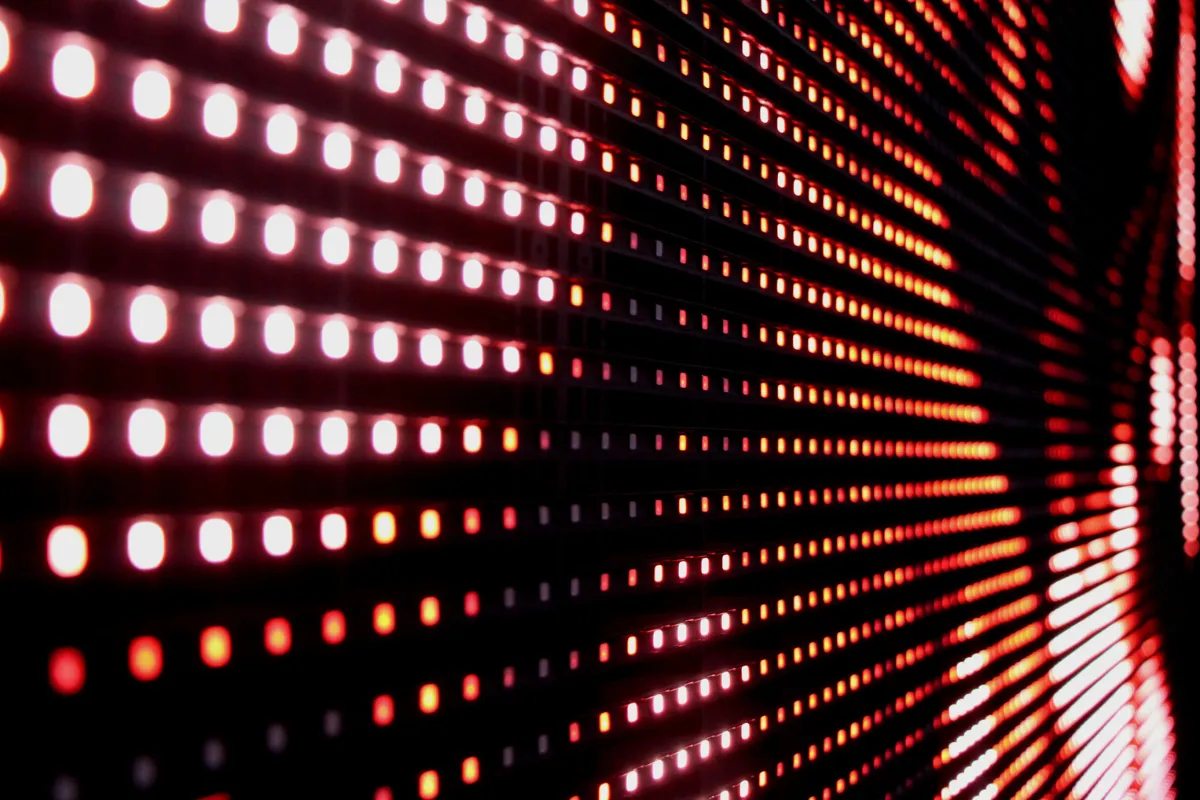 Painel de LED com diversos pontos de luz vermelha organizados em linhas sobre fundo escuro.