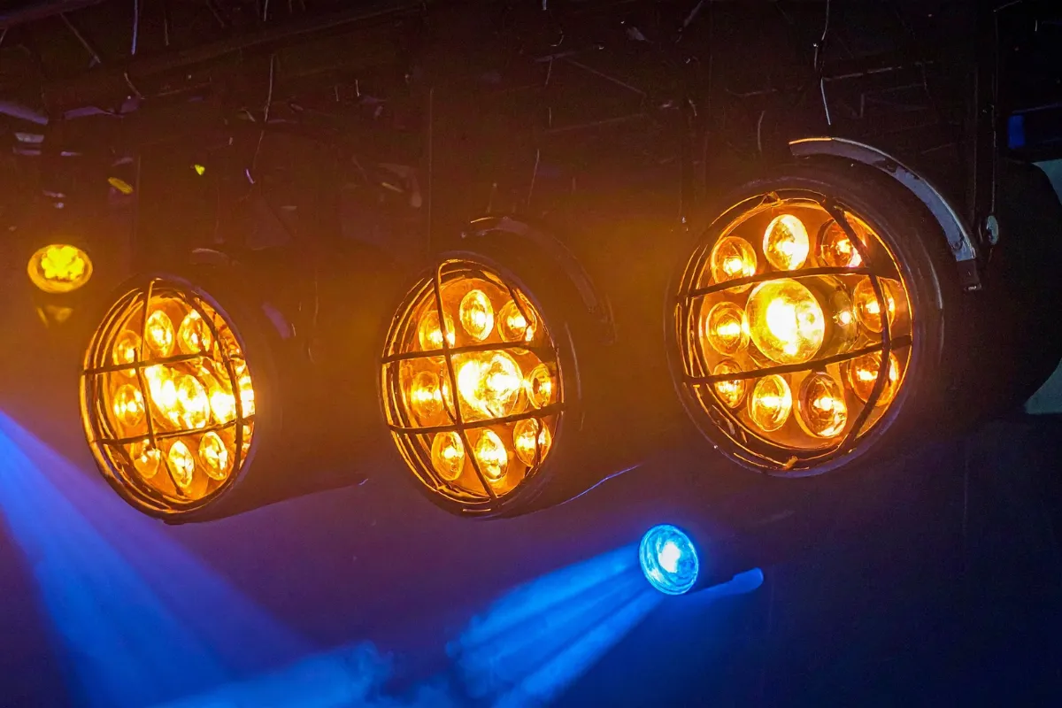 Refletores tipo spot com várias lâmpadas acesas em estrutura de iluminação de palco