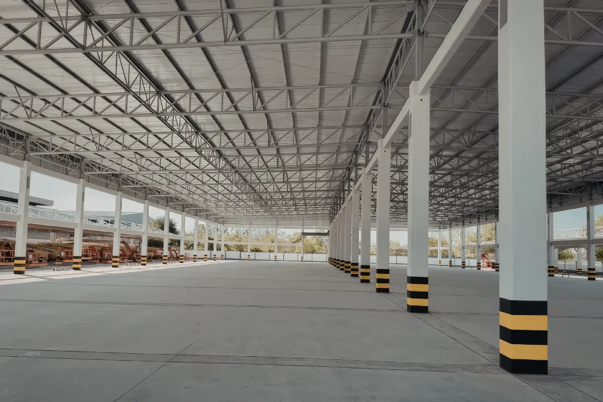 galpao amplo com estrutura metalica e colunas brancas em ambiente industrial